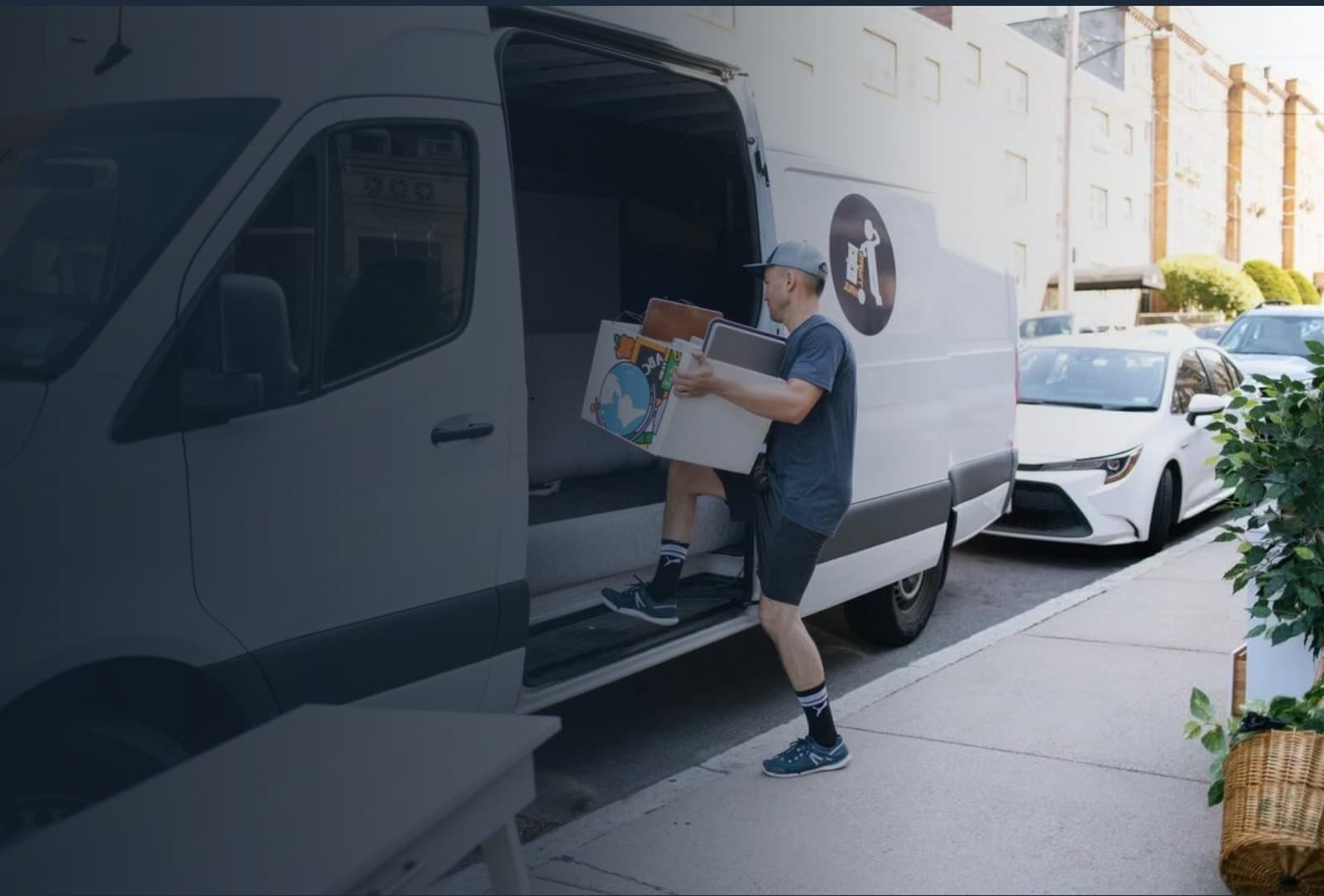 Small Haul hauler loading furniture into a Sprinter van on a Colorado street