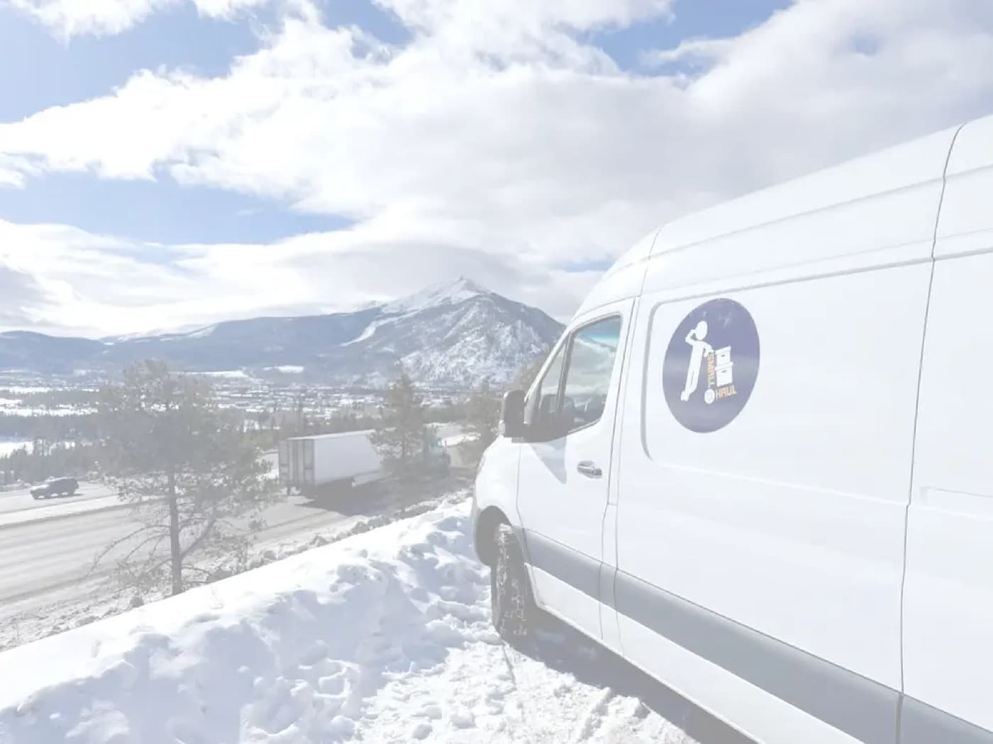 Small Haul van overlooking the snowy Colorado mountains
